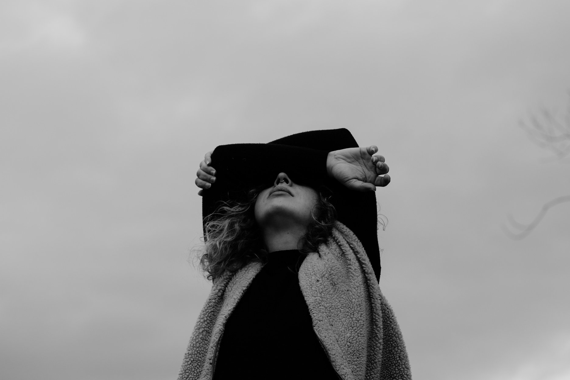 Grayscale Photo of Woman in Black Sleeves Covering Her Eyes